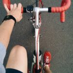 a hand reaches towards the handle bars of a bike