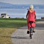A senior rides their bike towards the ocean